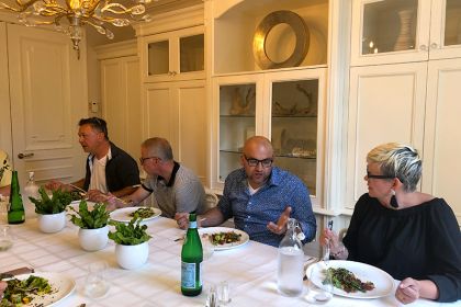 older people enjoying a vegan meal around a beautiful dining room table